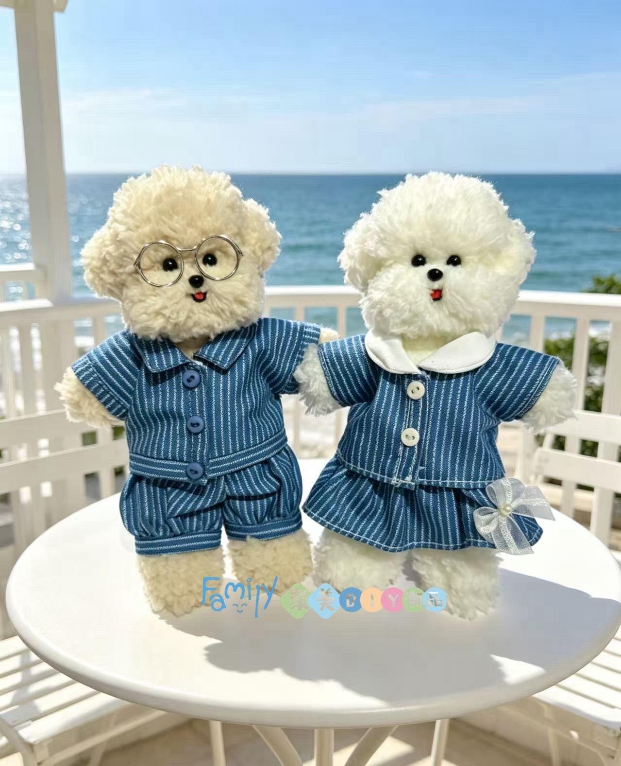 Two handmade puppies in matching blue outfits by the sea